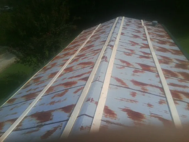 Rusted metal roof panels with new wood purlins before replacement — Storm Damage Roof Repair in Layton by Roofing Brothers