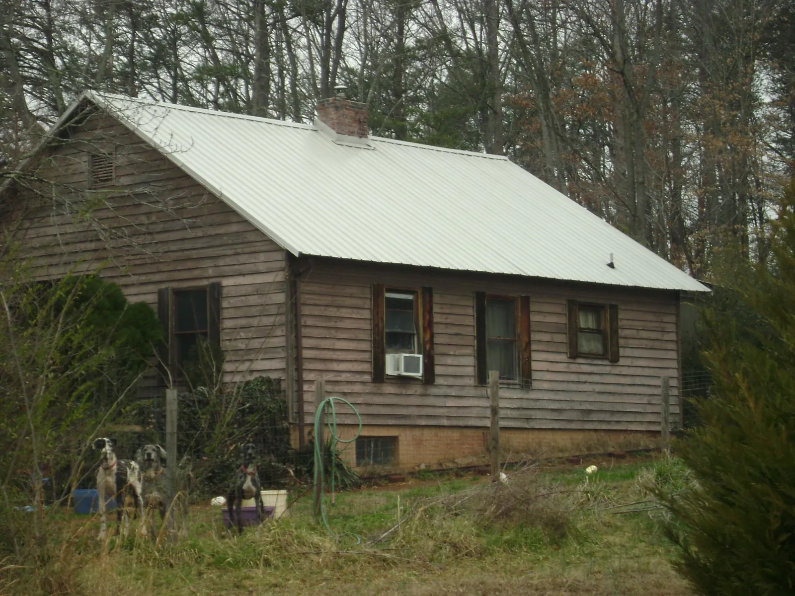 White metal roof on an old wood sided farmhouse, from a Metal Roof Installation job in Layton